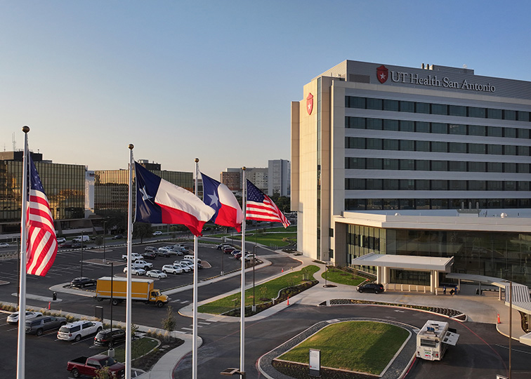 exterior photo of ut health hospital with flags in foreground